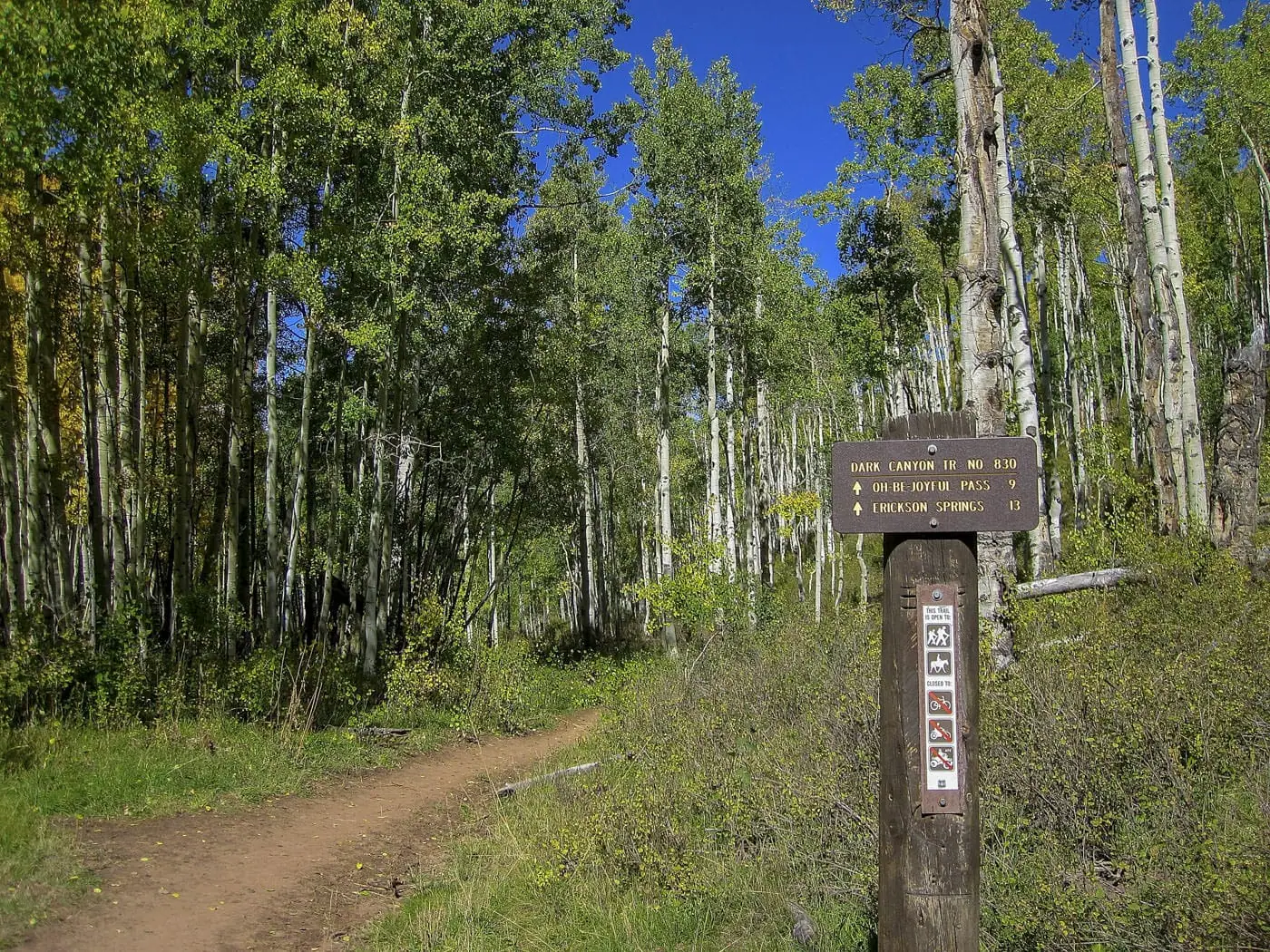 Dark Canyon and Dyke Trail signs past the green gate