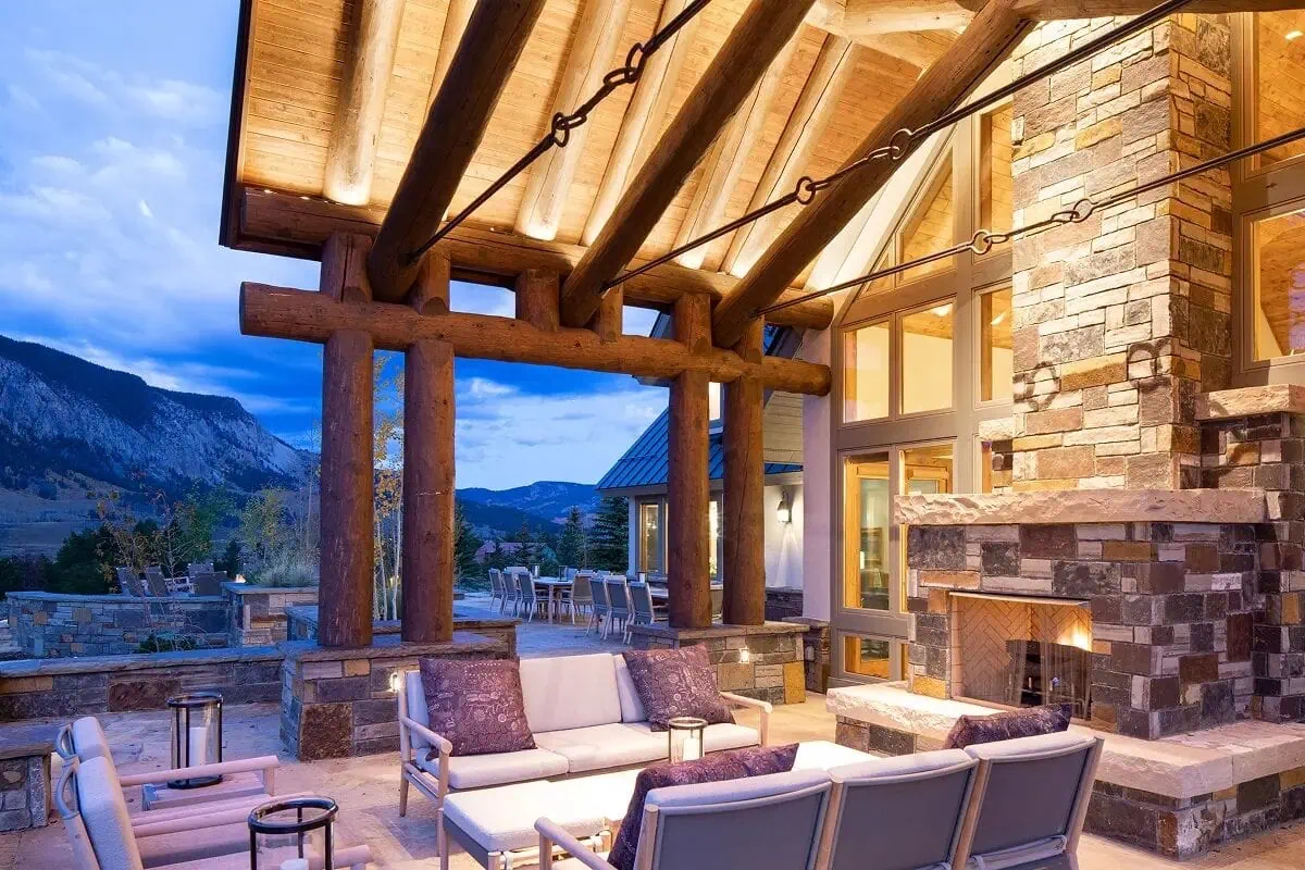 Outdoor stone fireplace on the timbered back porch with mountain views beyond
